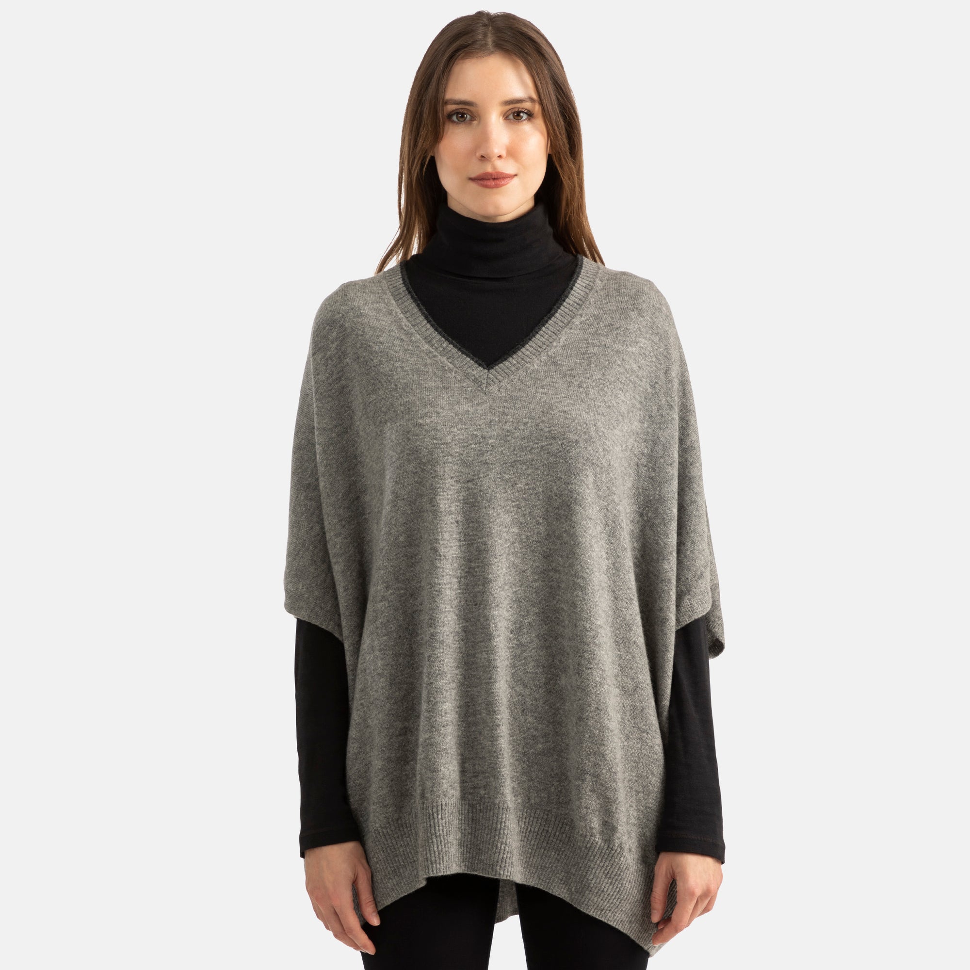 Picture of woman wearing an overhead v-neck ponch with contrast trim in grey with black trim