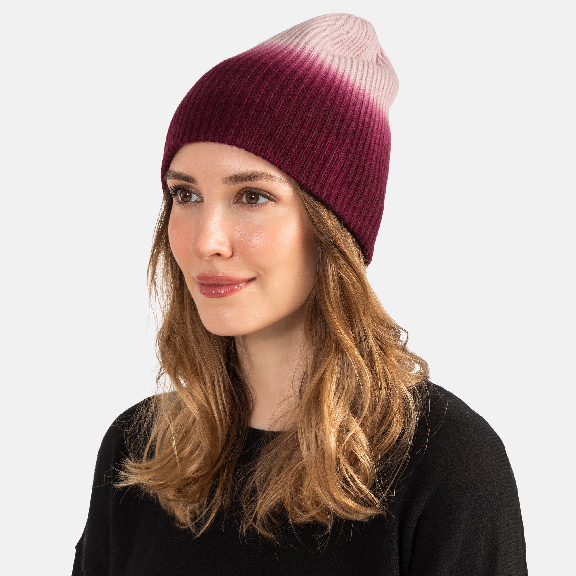 Picture of a woman in a chunky rib knit slouchy hat with an ombre design in pink to burgundy.