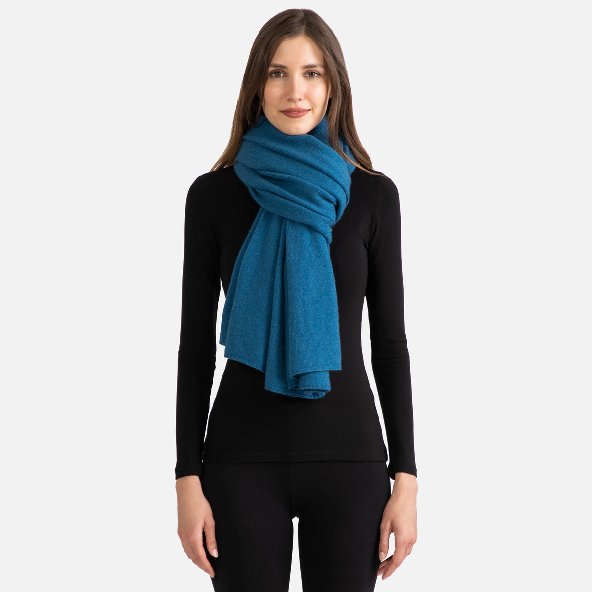 Picture of a woman wearing a teal cashmere jersey knitted oversize scarf or travel wrap.