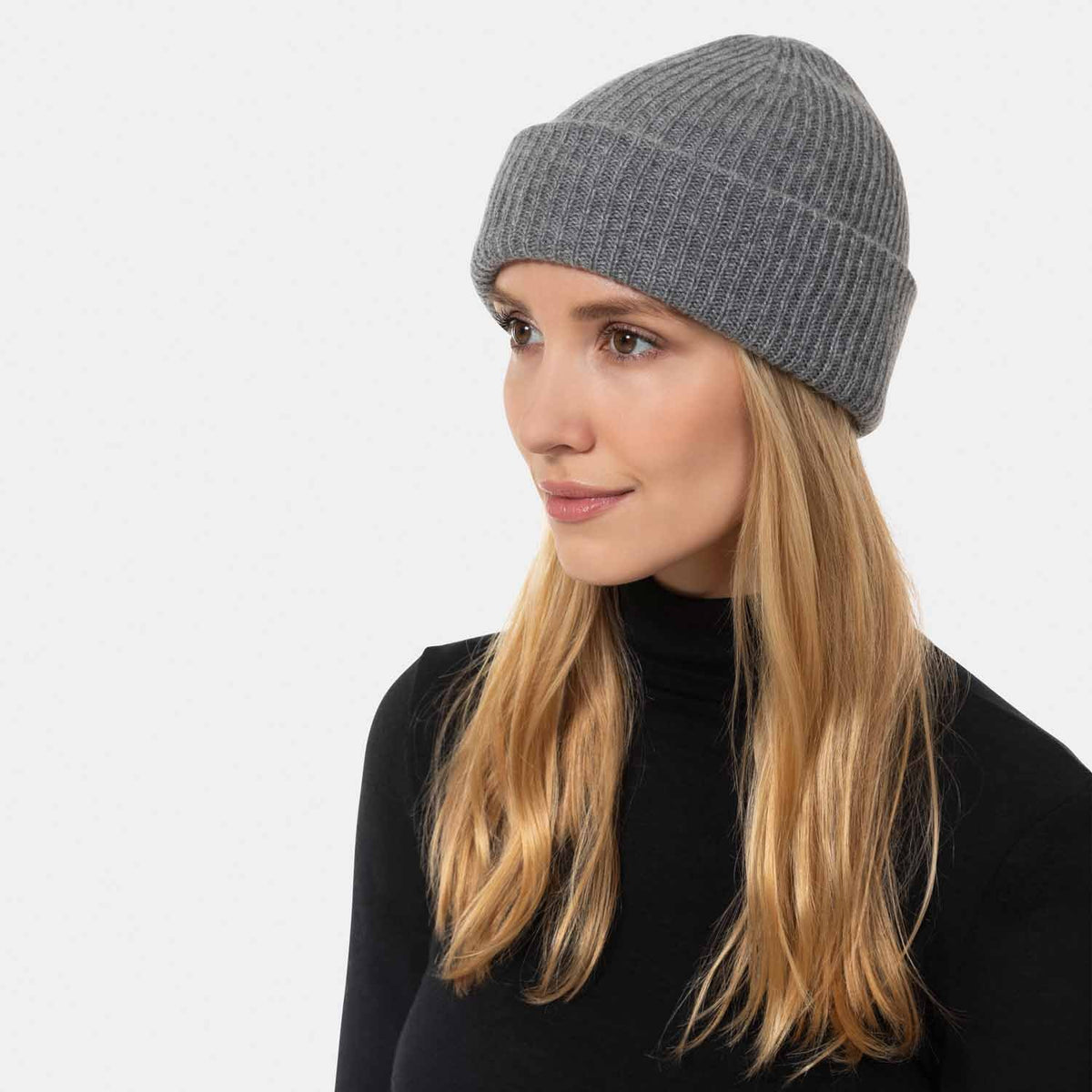 Picture of a woman wearing a double layer rib knit hat in red.