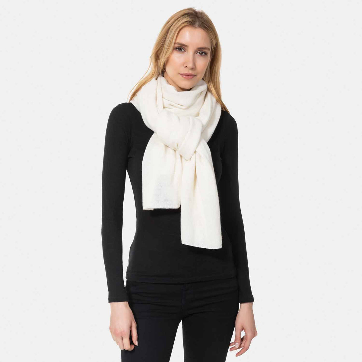 Picture of a woman wearing a Ivory cashmere jersey knitted oversize scarf or travel wrap.