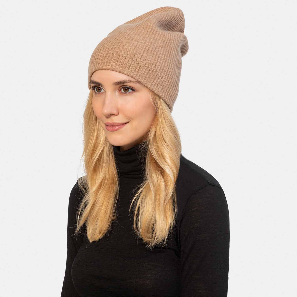 Picture of a woman in a reversible rib knit hat, navy and oatmeal.