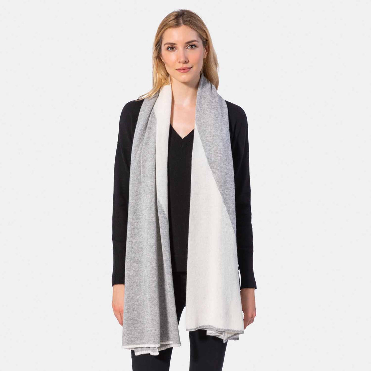 Picture of a woman in a two tone cashmere knit scarf, black and charcoal.