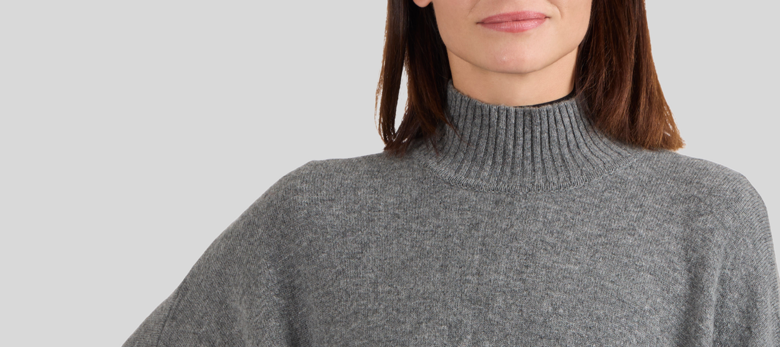 Contact Us: woman wearing gray cashmere funnel neck poncho