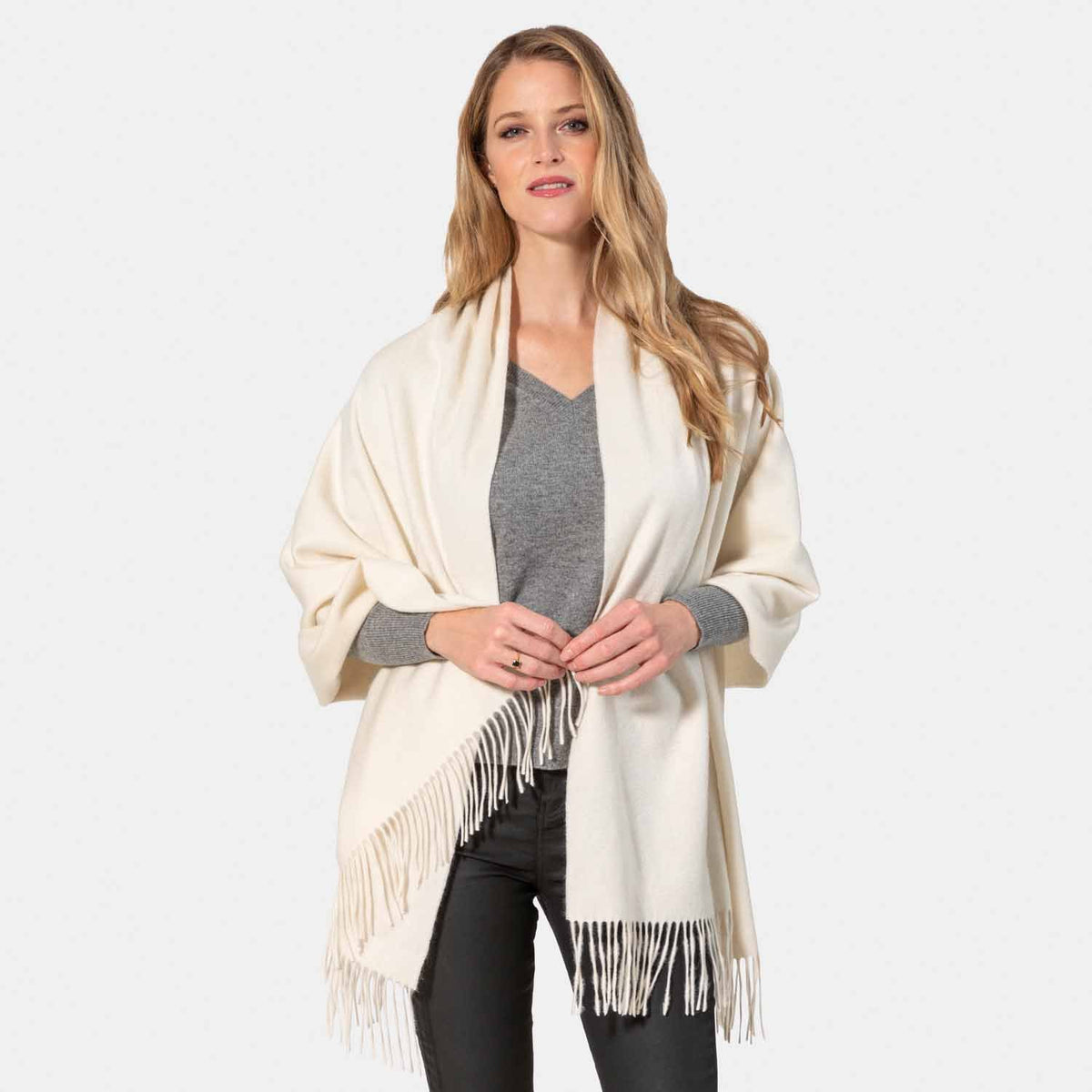 Picture of a woman wearing an oversized cashmere wrap with fringe, Ivory.