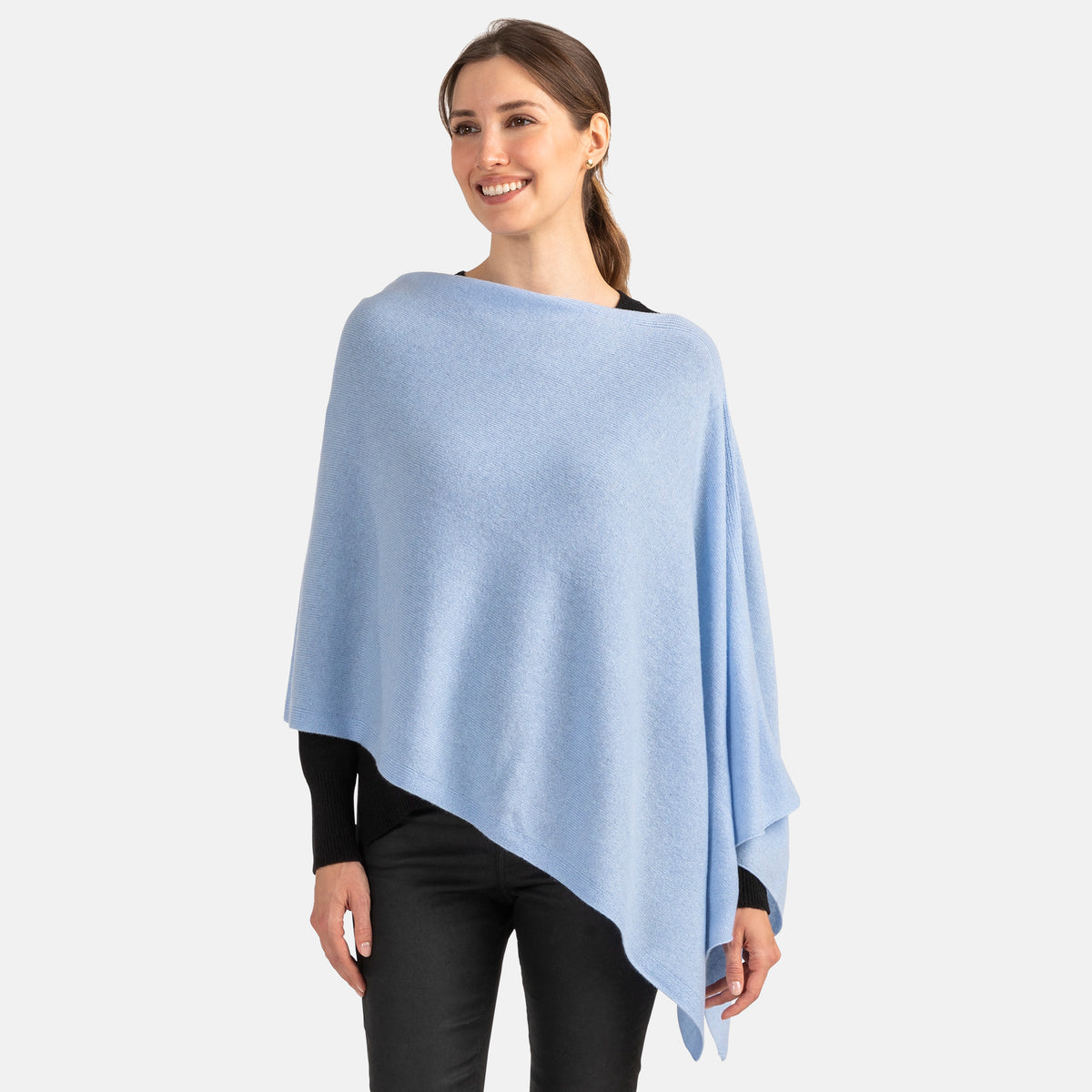 Picture of a woman wearing an asymmetrical ove the head poncho, light blue.