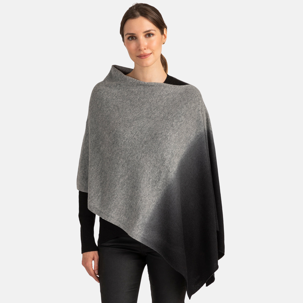 Picture of a woman wearing an assymetrical cashmere knit over the head poncho with dip dye patter in oatmeal and brown.