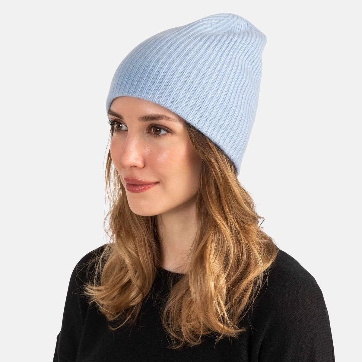 Picture of a woman wearing a double layer rib knit hat in orange.