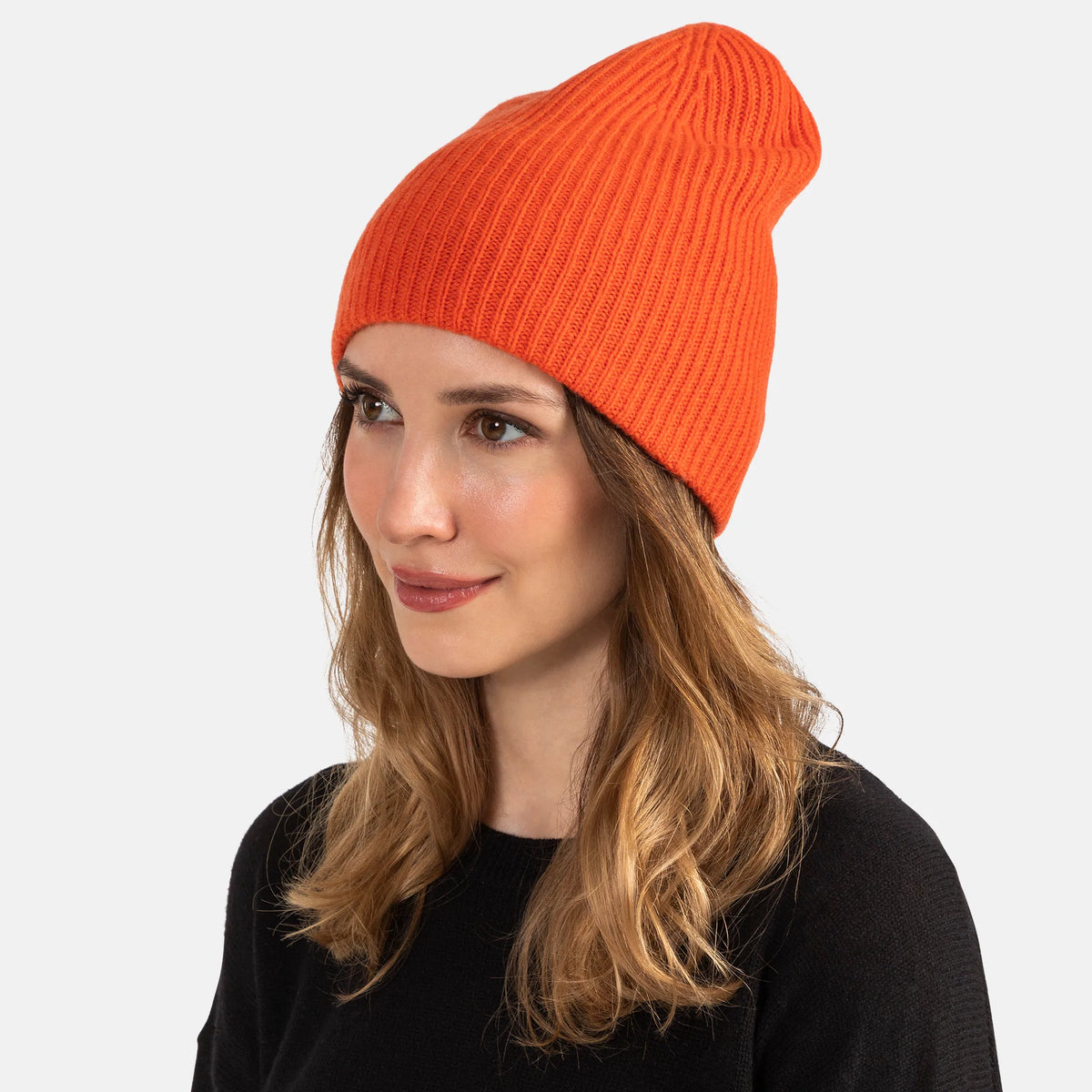 Picture of a woman wearing a double layer rib knit hat in orange.