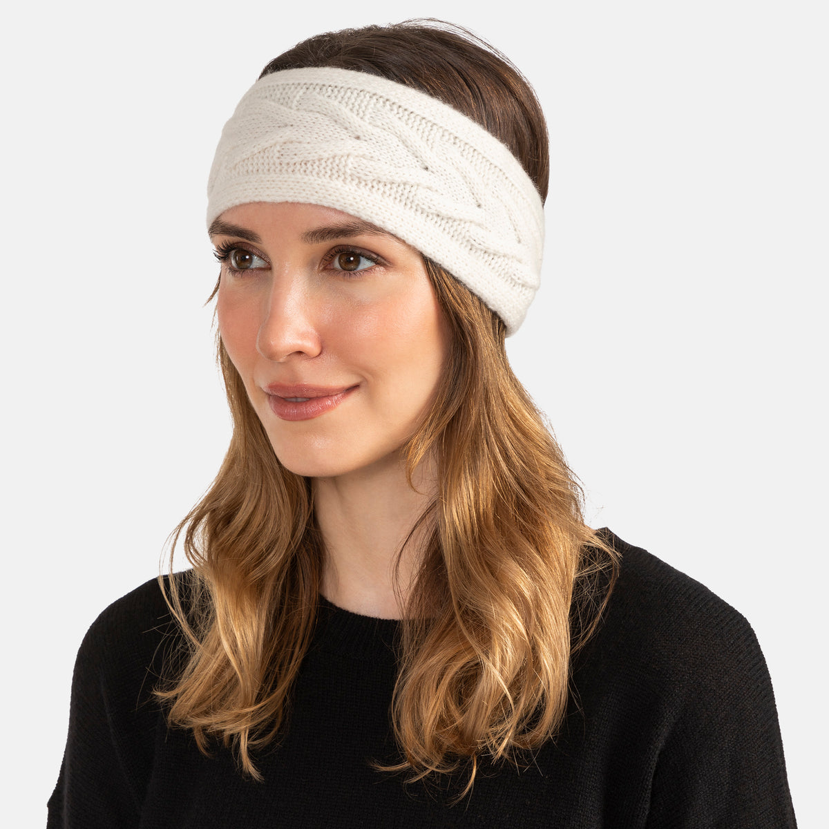 Picture of a woman wearing a knitted cashmere headband with a trellis cable design in soft pink.
