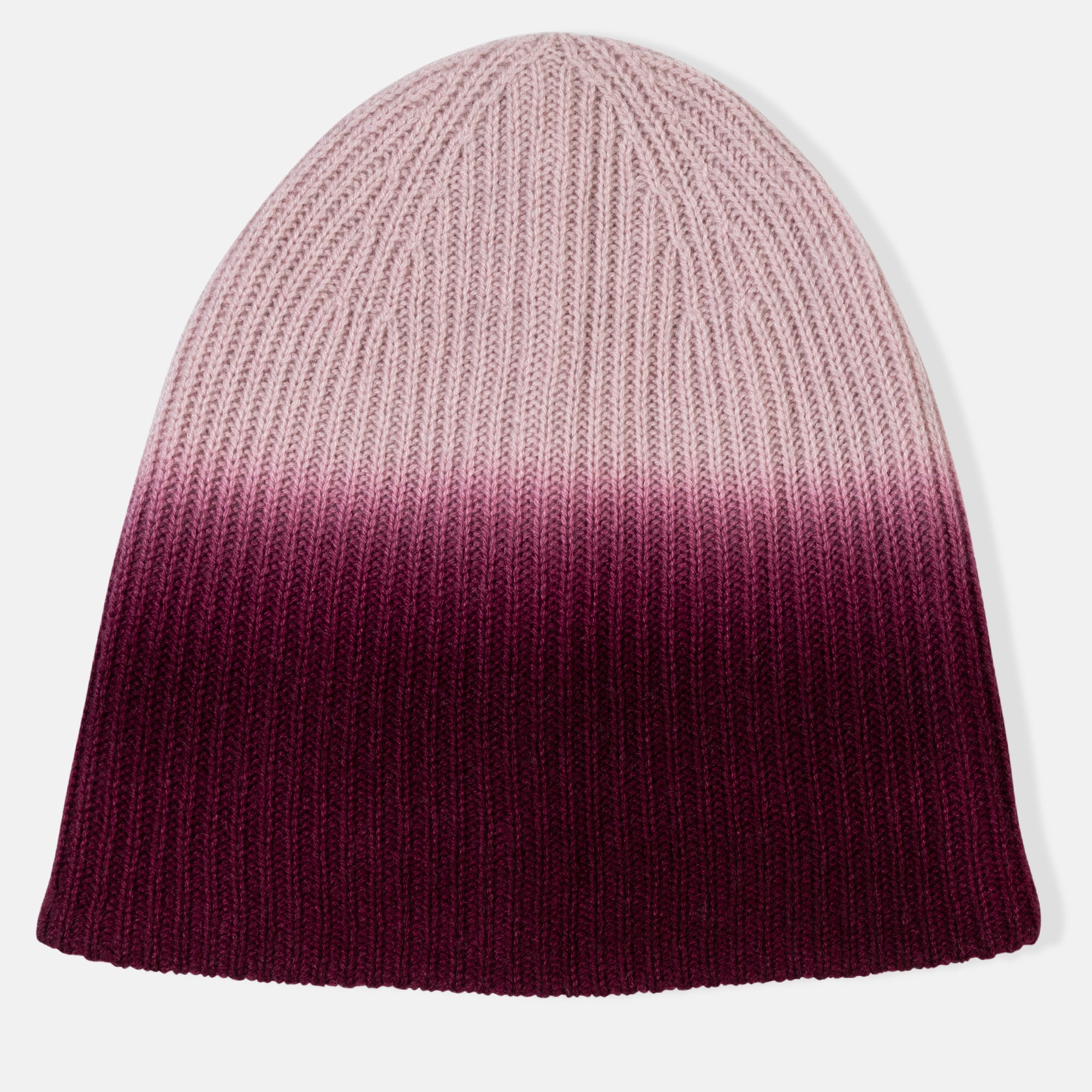 Picture of a woman in a chunky rib knit slouchy hat with an ombre design in pink to burgundy.