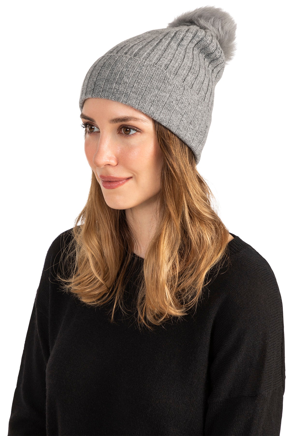 Woman wearing a Navy cashmere beanie with shearling pom, rib knit detail.