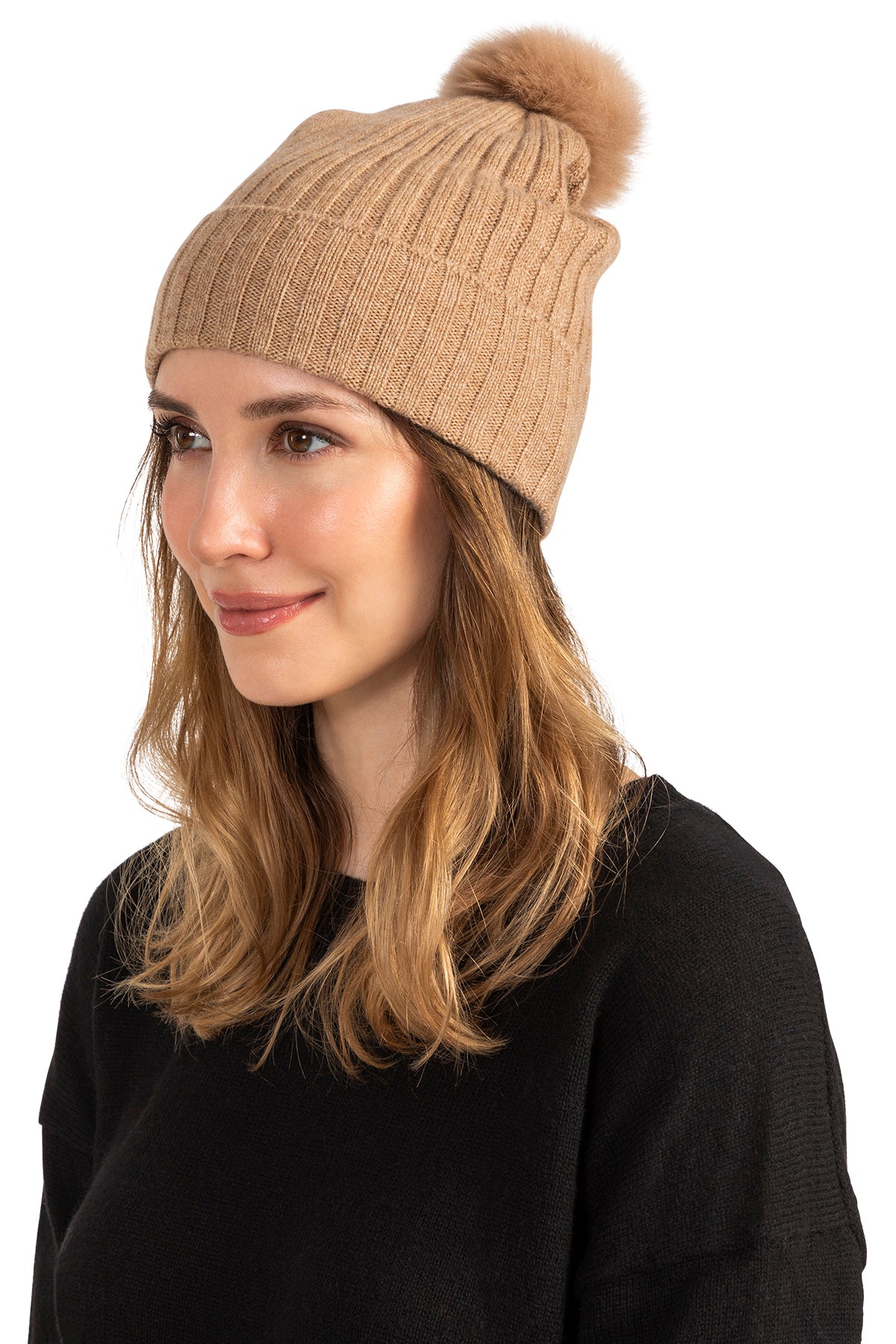 Woman wearing an Ivory cashmere beanie with shearling pom, rib knit detail.
