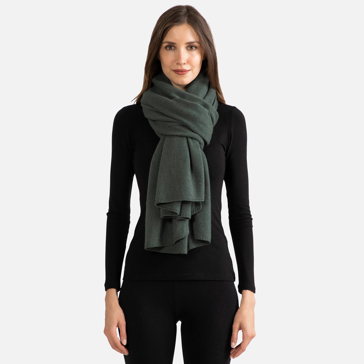 Picture of a woman wearing a dark green cashmere jersey knitted oversize scarf or travel wrap.
