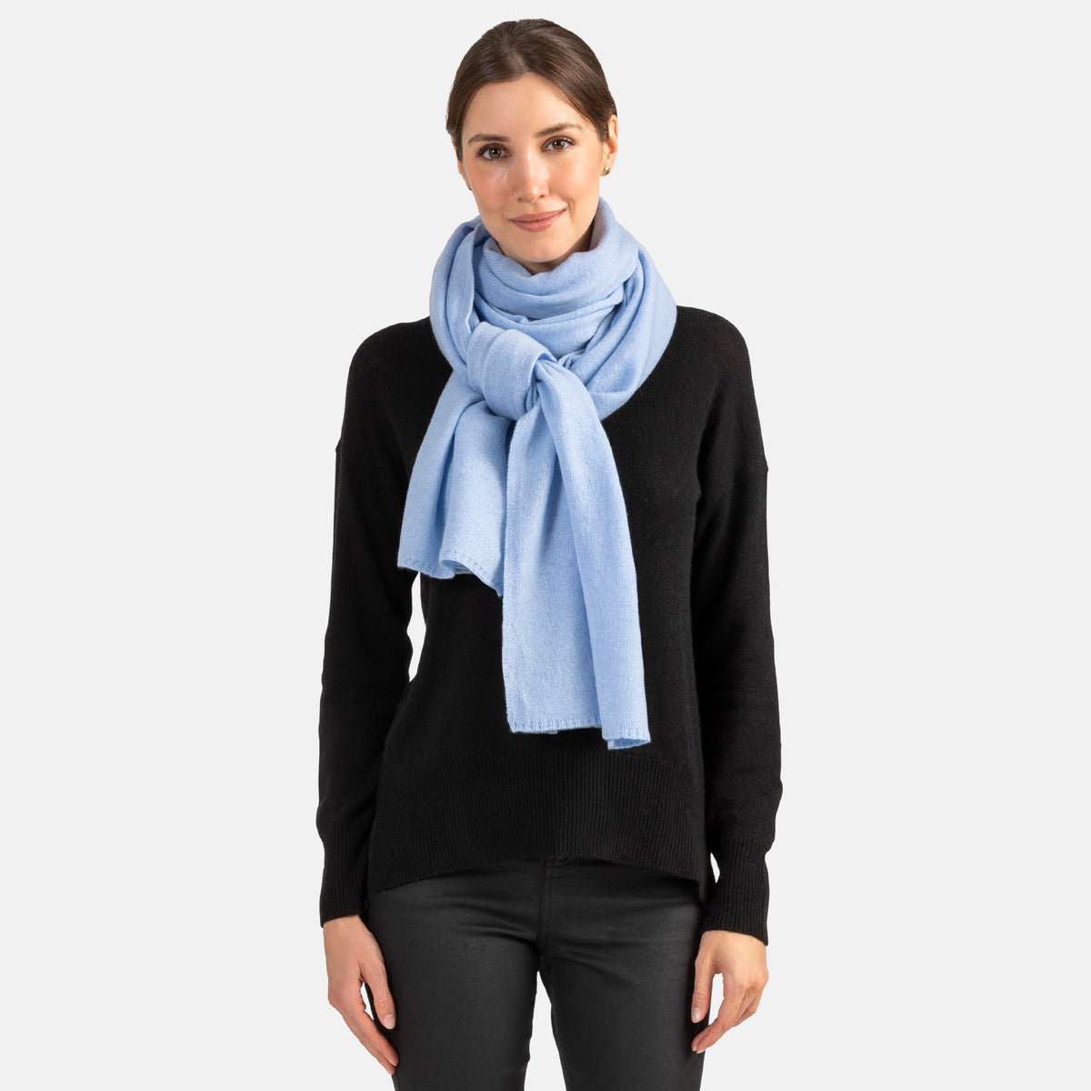 Picture of a woman wearing a light blue cashmere jersey knitted oversize scarf or travel wrap.