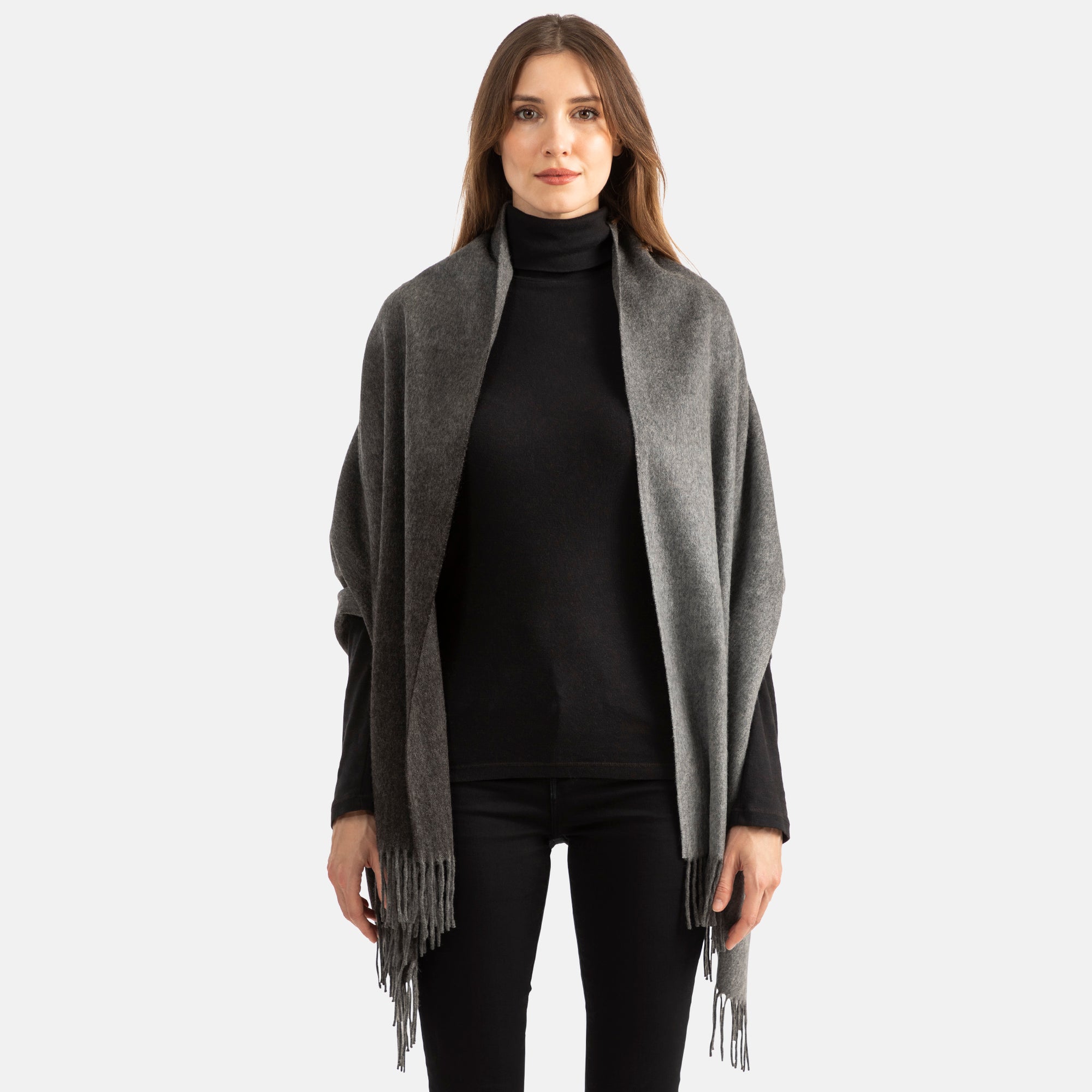 Picture of a woman wearing a double face, long woven cashmere wrap with fringe,in two tones of grey with ombre design.