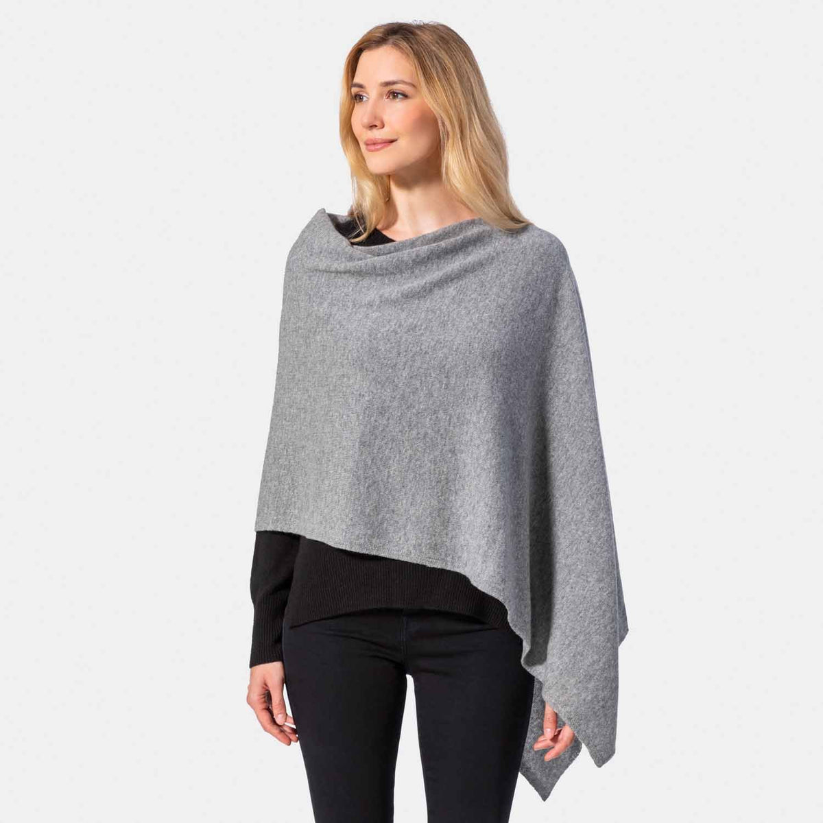 Picture of a woman wearing an asymmetrical ove the head poncho, camel.