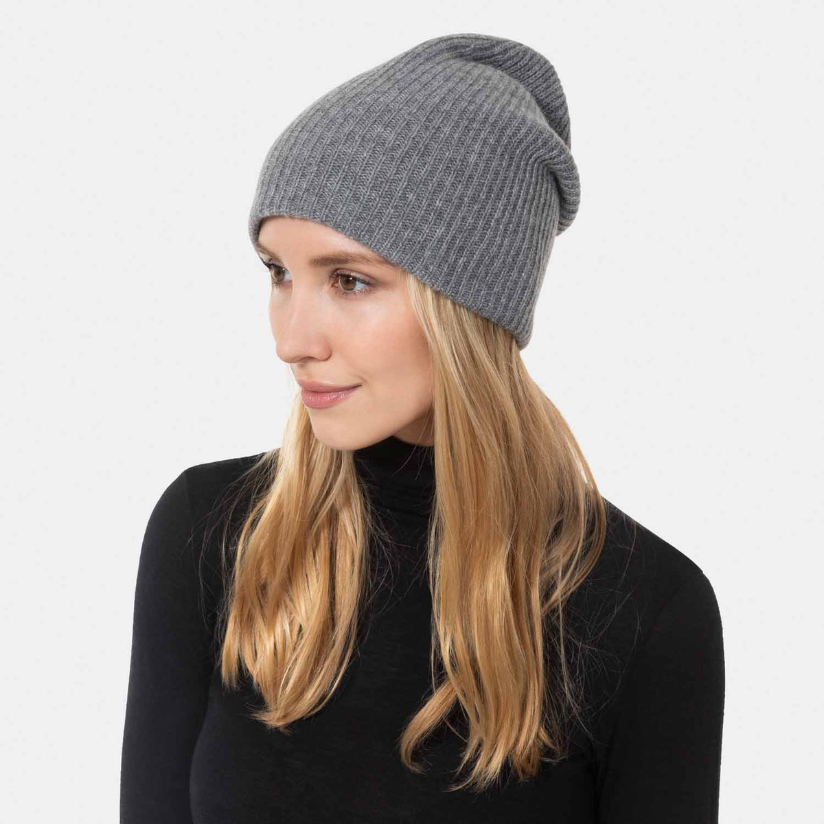 Picture of a woman wearing a double layer rib knit hat in plum.
