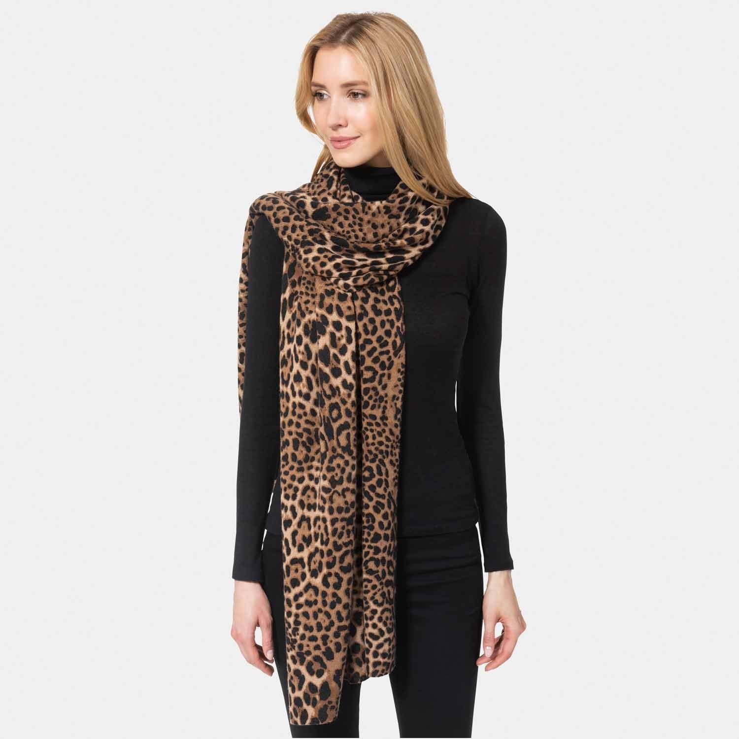 Picture of a woman wearing a knit scarf in cheetah print, camel and black.