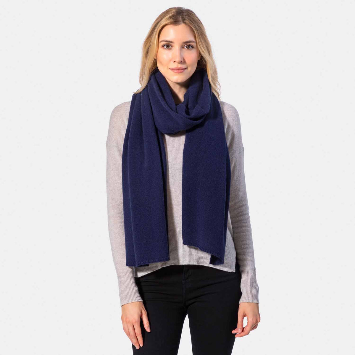 Picture of a woman wearing a navy cashmere jersey knitted oversize scarf or travel wrap.