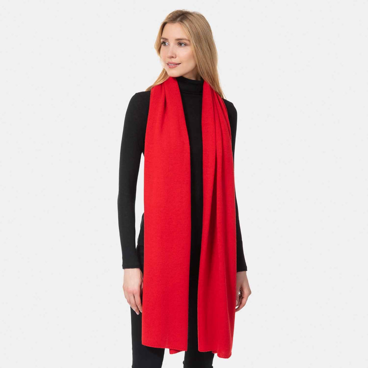 Picture of a woman wearing a red cashmere jersey knitted oversize scarf or travel wrap.