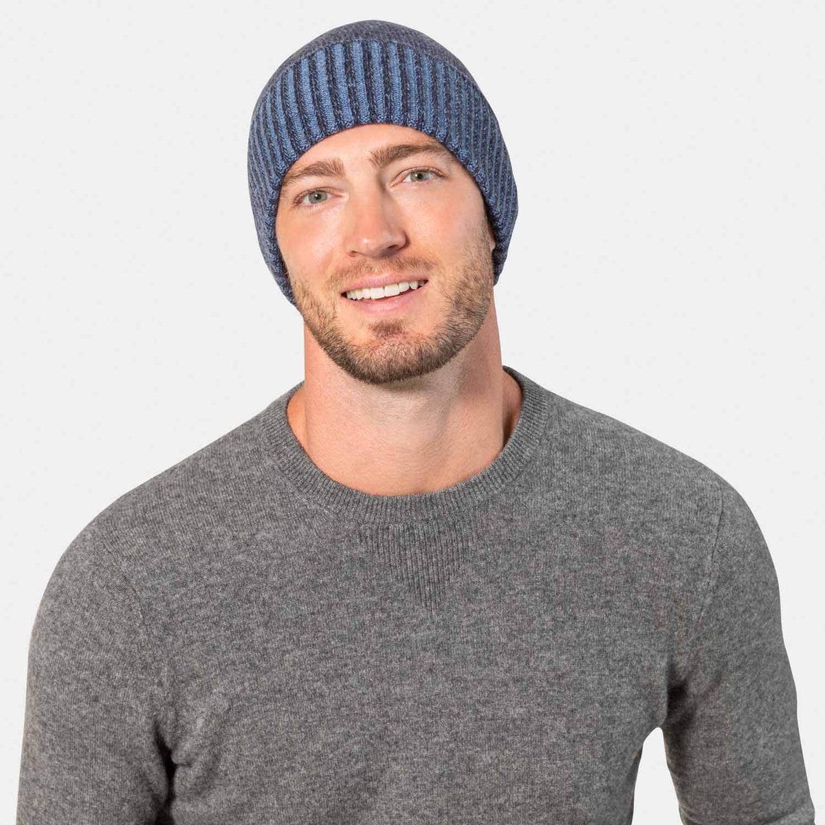 Picture of a man wearing a plaited knit hat with contrast cuff in black and grey.