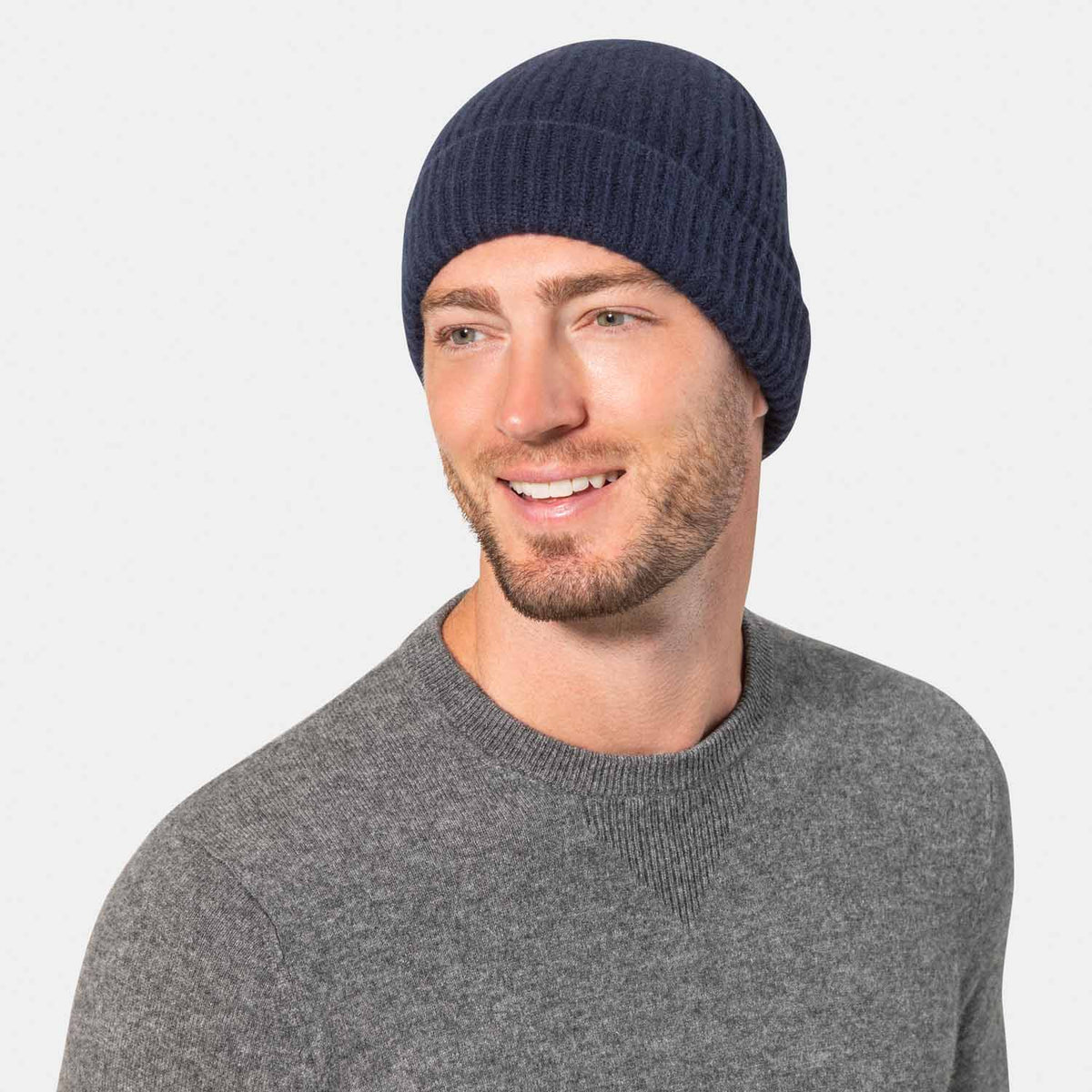 Picture of a man wearing acashmere cardigan rib knit hat in navy.