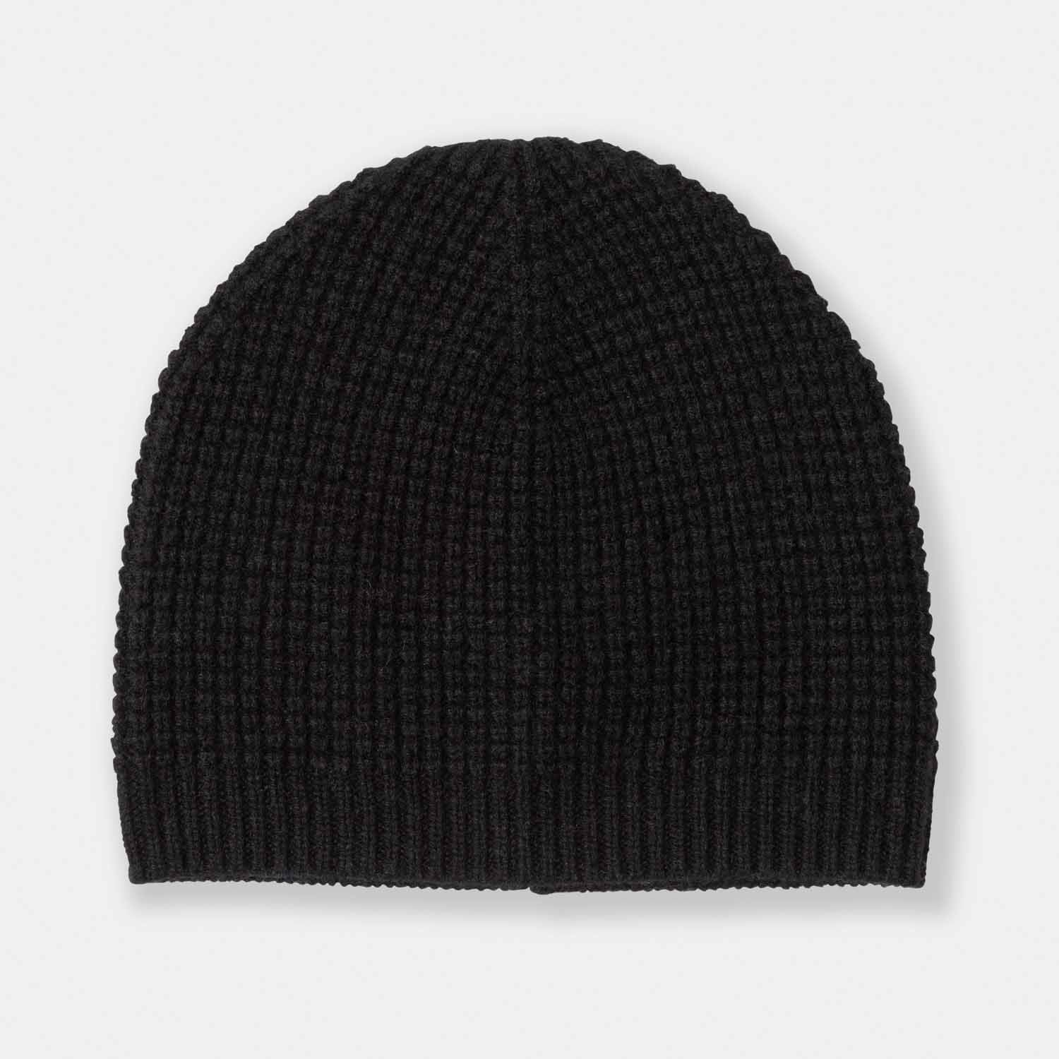 Picture of a man wearing a waffle knit cuffed hat in black.