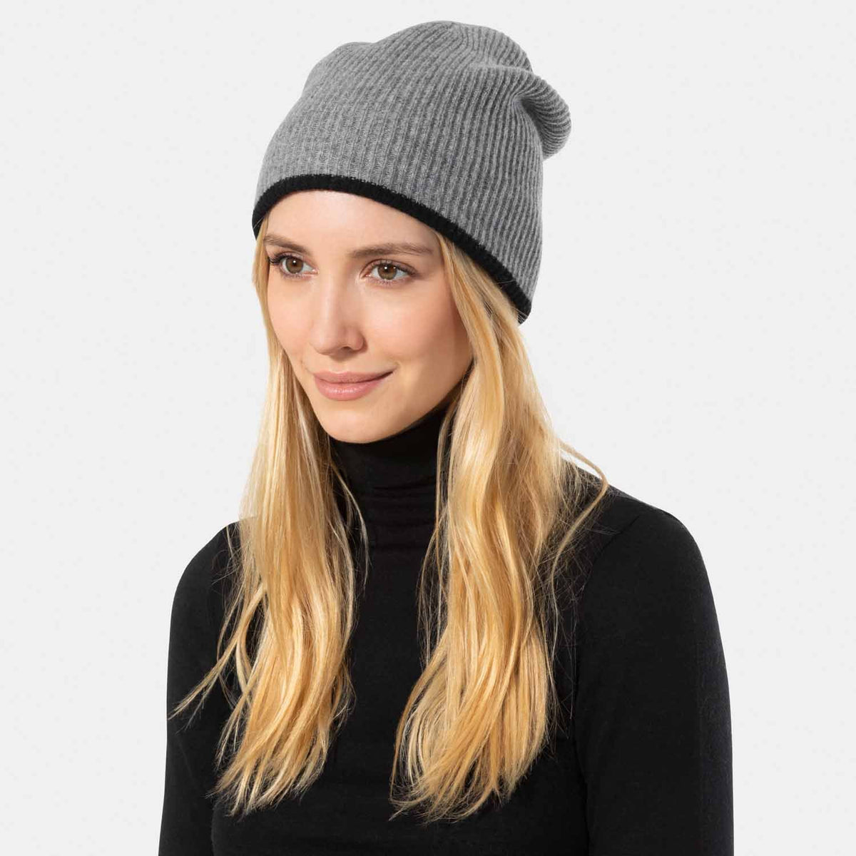 Picture of a woman in a reversible rib knit hat, light grey and cream