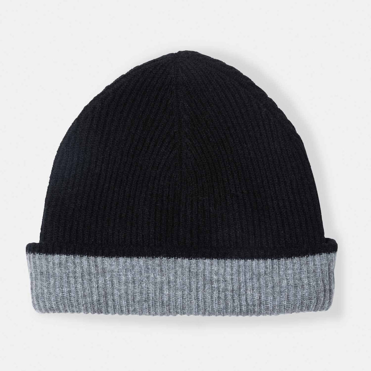 Picture of a woman in a reversible rib knit hat, grey and black.
