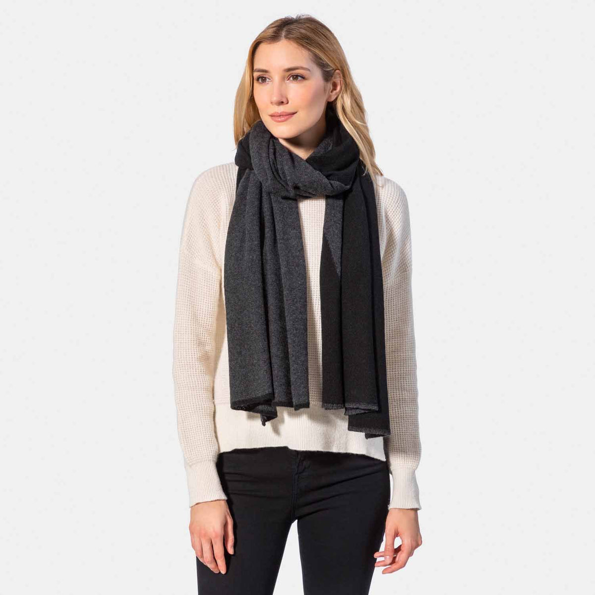 Picture of a woman in a two tone cashmere knit scarf, grey and camel.