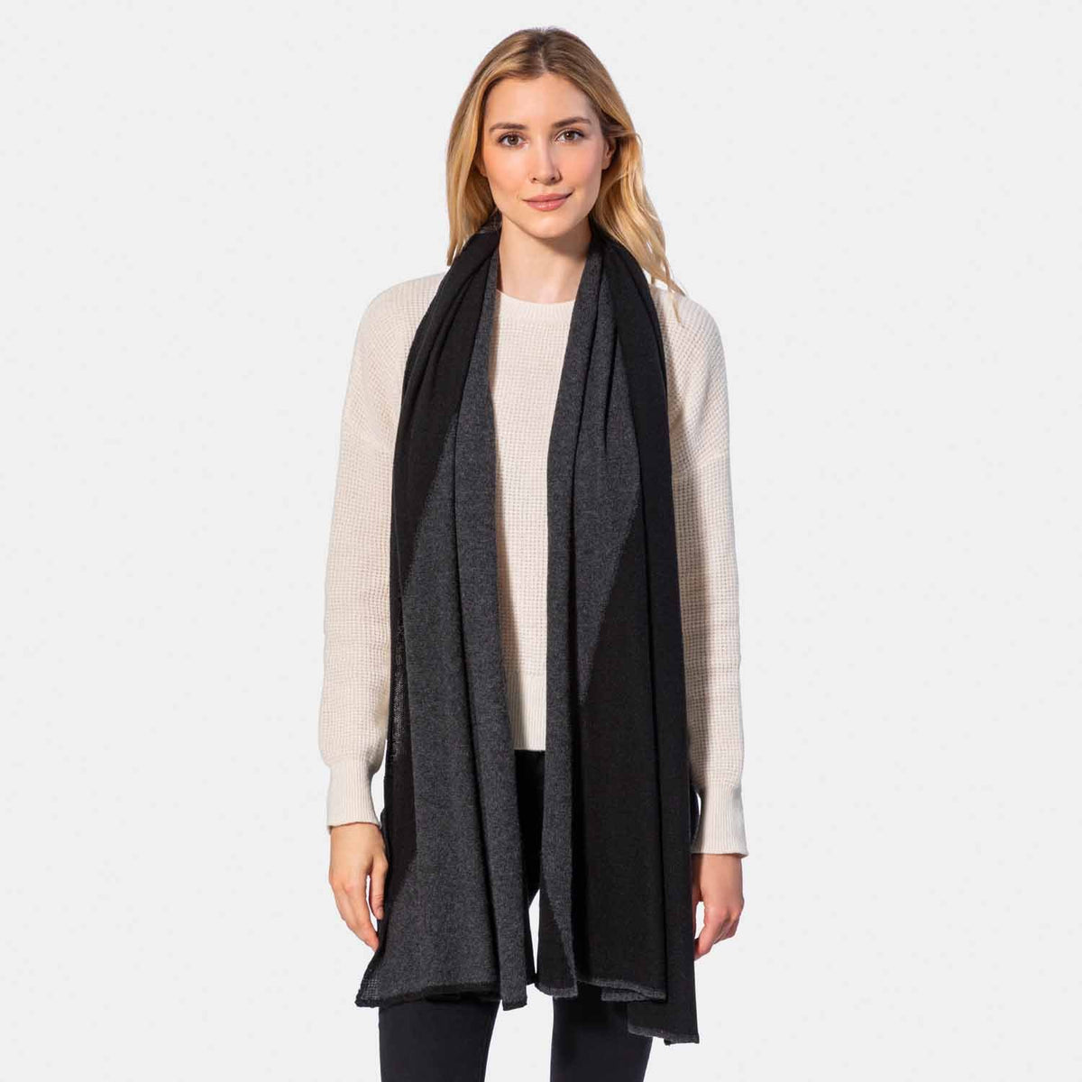 Picture of a woman in a two tone cashmere knit scarf, navy and oatmeal.