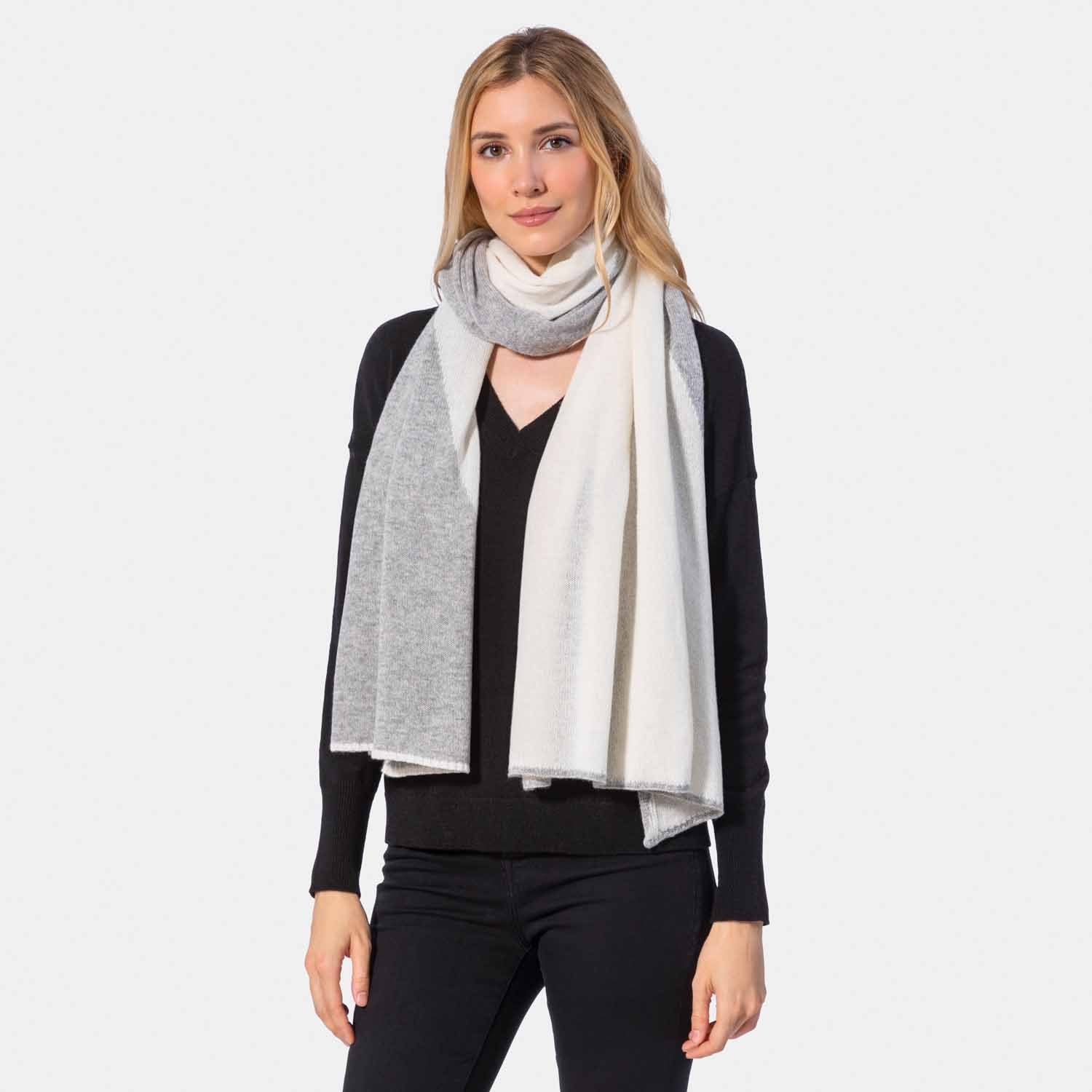 Picture of a woman in a two tone cashmere knit scarf, light grey and cream.